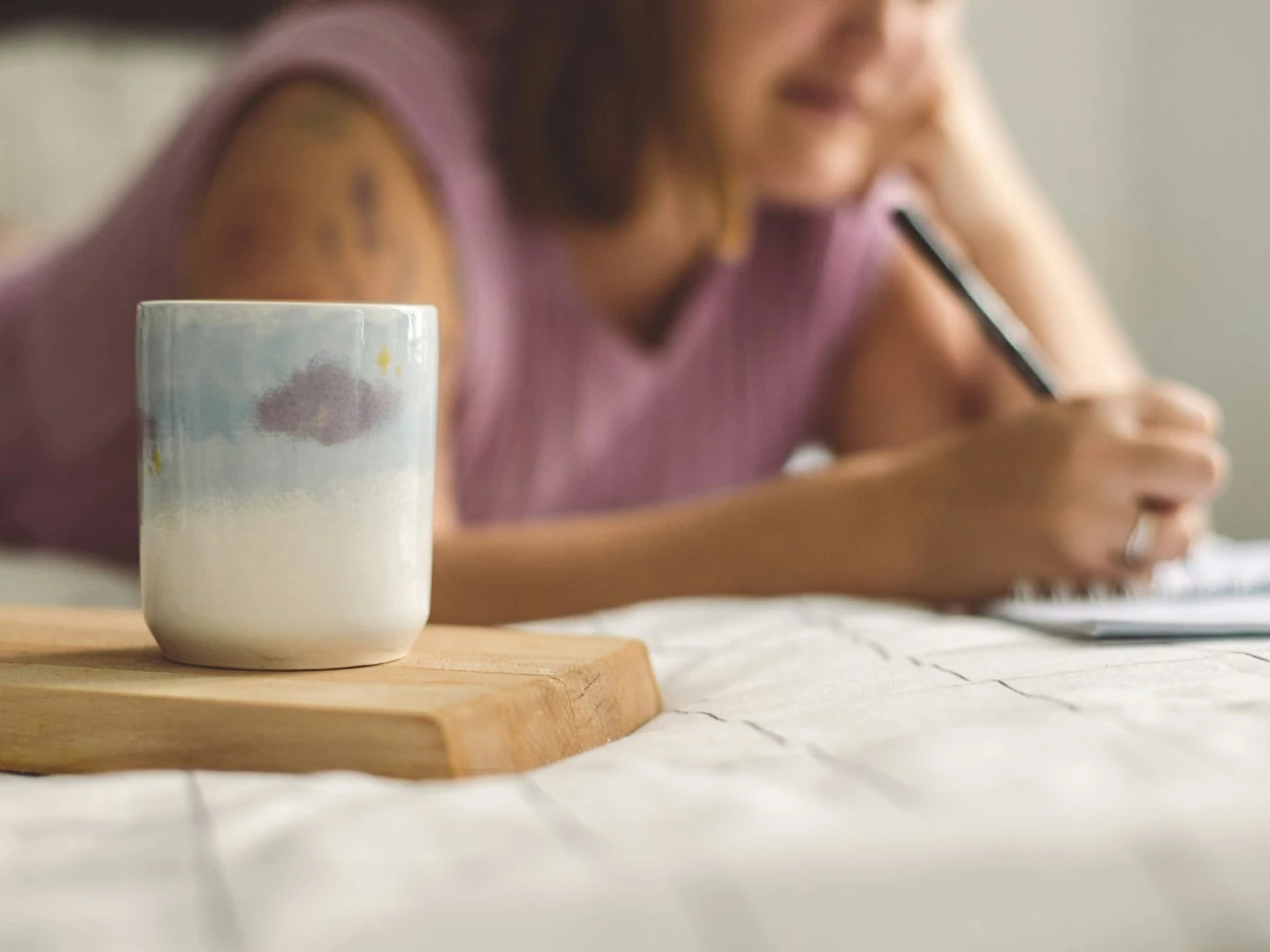 AnimateImage scene: woman writing in a notepad next to a ceramic cup