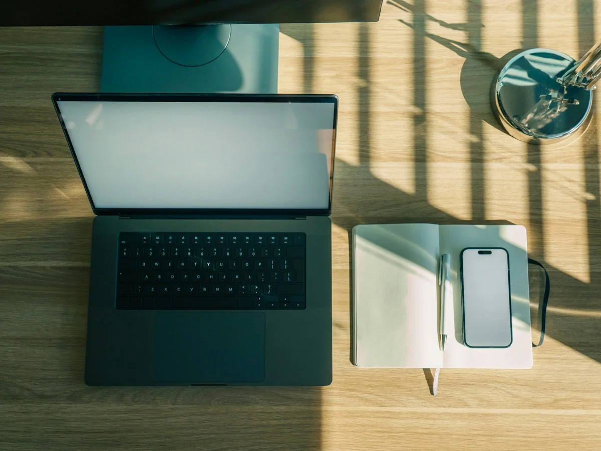 AnimateImage top view of a laptop, phone and notebook on a wooden desk
